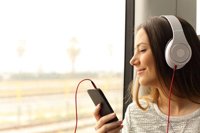 a person listening to music with headphones from their phone.