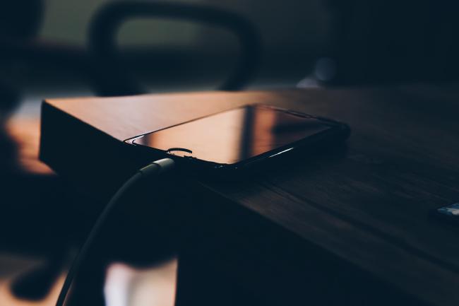Phone charging next to bed at night.