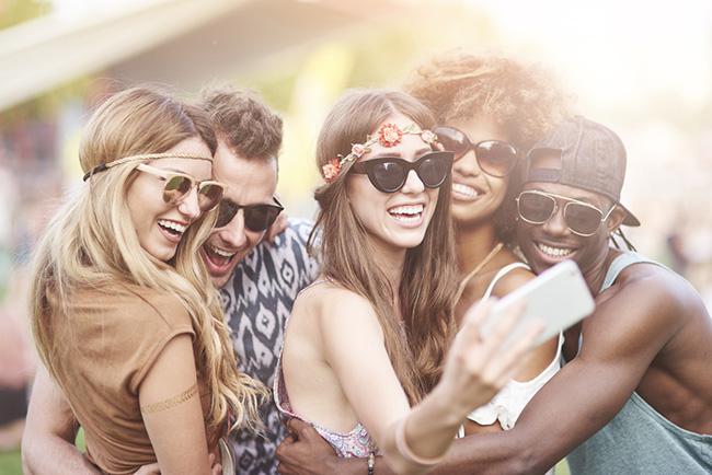 A group of 4 friends having fun outside at a festival.