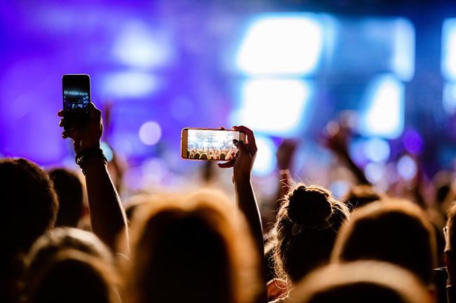 A person recording a performance at a festival.